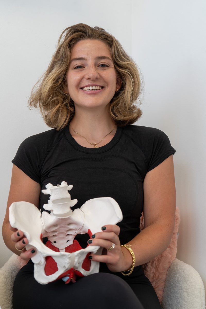 Erica Bermudez, OTR/L, founder of The Pelvic Floor OT, holding a pelvic model in her Bayonne office